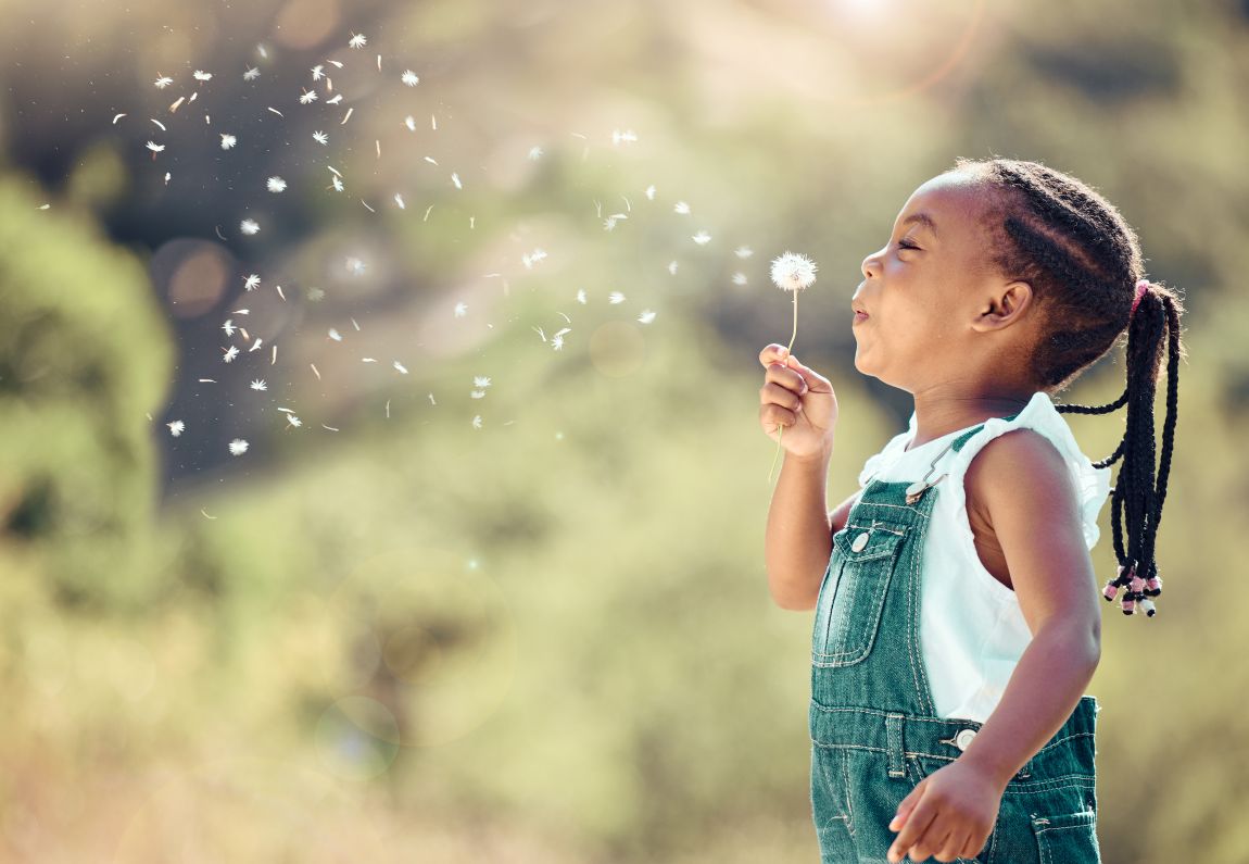 Sinusitis-Pediatric-symptoms child blowing on a dandelion